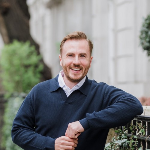 GP and sexologist Dr Ben Davis, wearing a navy pullover and smiling at the camera